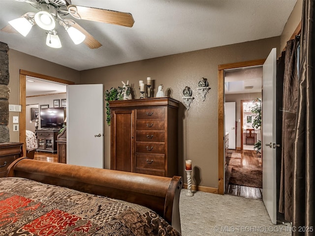 bedroom featuring light colored carpet, ceiling fan, and baseboards