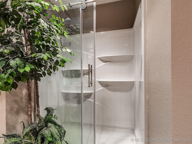 bathroom view of a textured wall and a shower stall