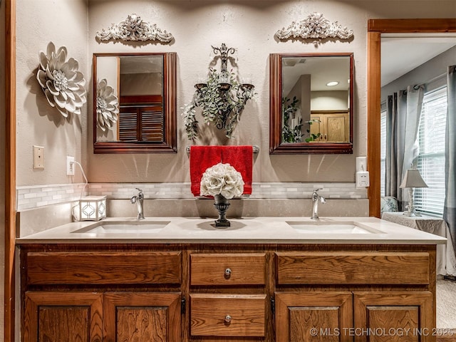 bathroom featuring double vanity and decorative backsplash