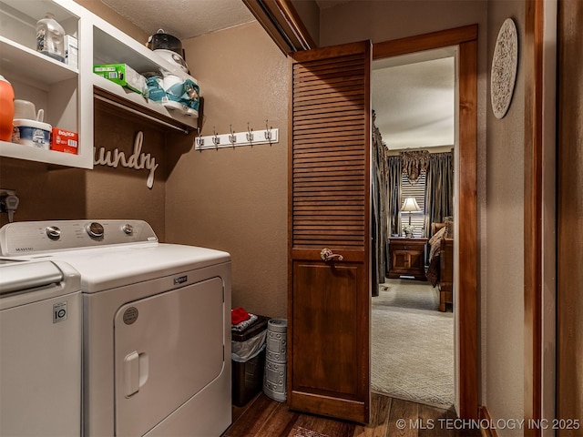 laundry room featuring washing machine and clothes dryer, dark wood-style flooring, and a textured wall
