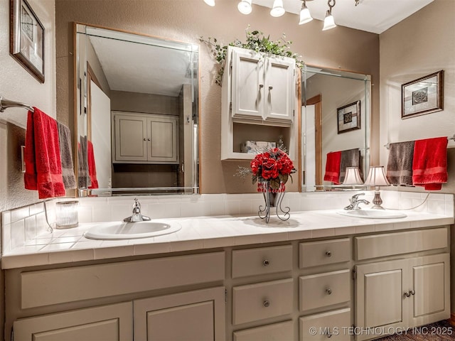 full bath featuring double vanity and a textured wall