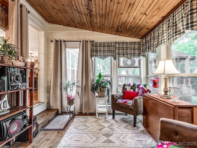 living area featuring vaulted ceiling, wooden ceiling, and wood finished floors