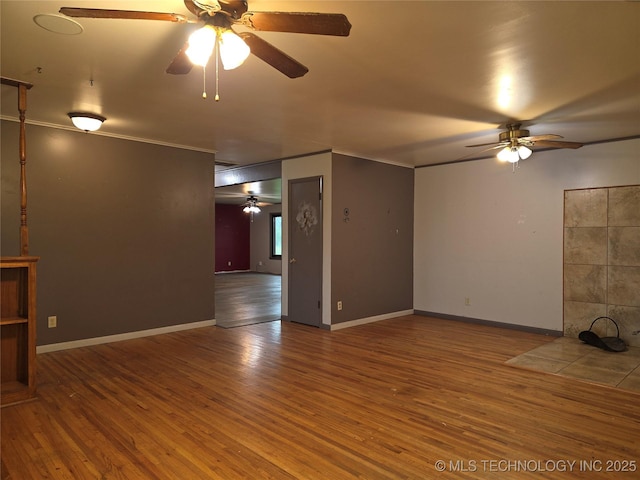 unfurnished living room with a ceiling fan, wood finished floors, ornamental molding, and baseboards