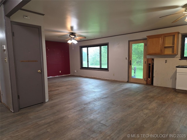 unfurnished living room featuring ceiling fan and wood finished floors