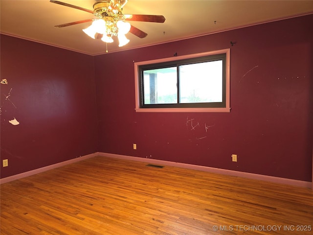 unfurnished room featuring wood finished floors, ceiling fan, ornamental molding, and baseboards
