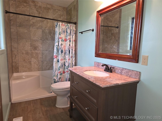 bathroom featuring curtained shower, wood finished floors, vanity, and toilet