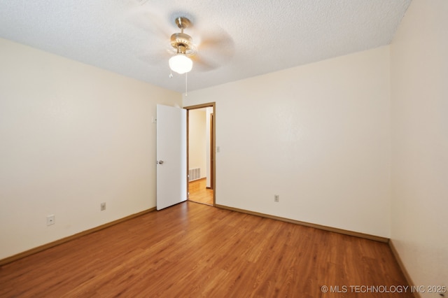 2925 S 125th E Ave, Tulsa, OK 74129 - unfurnished room with light wood finished floors, a ceiling fan, baseboards, and a textured ceiling