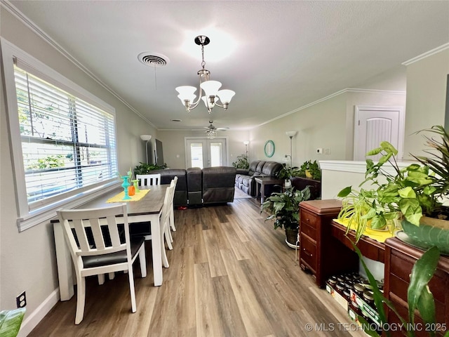 205 NE 1st St, Kingston, OK 73439 - dining space featuring a chandelier, wood finished floors, crown molding, a ceiling fan, and baseboards