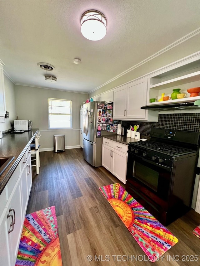 205 NE 1st St, Kingston, OK 73439 - kitchen with black gas range oven, ornamental molding, white cabinetry, dark countertops, and dark wood-style floors