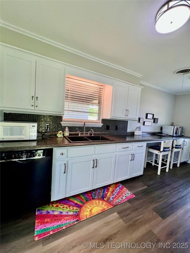 205 NE 1st St, Kingston, OK 73439 - kitchen featuring white microwave, black dishwasher, a sink, crown molding, and dark wood-type flooring