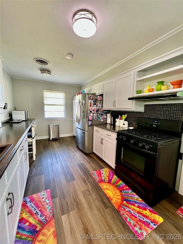 205 NE 1st St, Kingston, OK 73439 - kitchen featuring black gas stove, crown molding, white cabinets, dark countertops, and dark wood-type flooring