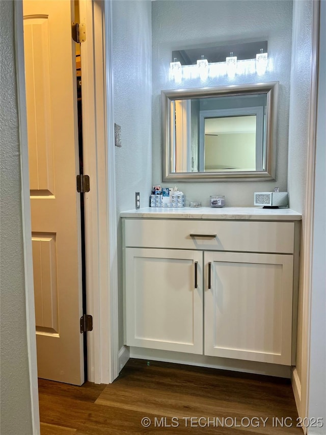 205 NE 1st St, Kingston, OK 73439 - bathroom featuring wood finished floors, vanity, and a textured wall