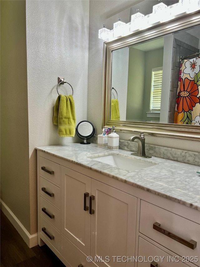 205 NE 1st St, Kingston, OK 73439 - bathroom with vanity, wood finished floors, baseboards, and a textured wall