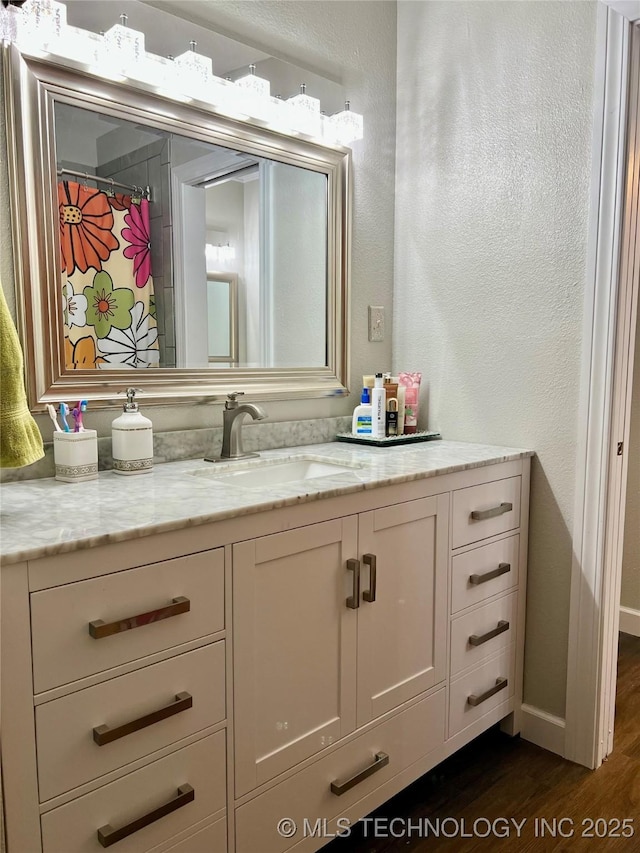 205 NE 1st St, Kingston, OK 73439 - bathroom featuring wood finished floors, vanity, and a textured wall