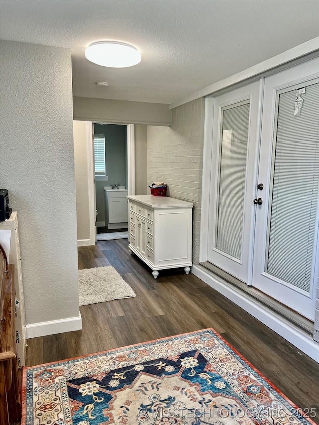 205 NE 1st St, Kingston, OK 73439 - hall featuring dark wood-style floors and baseboards