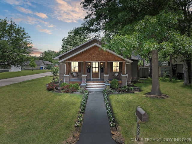 bungalow-style house featuring covered porch and a yard