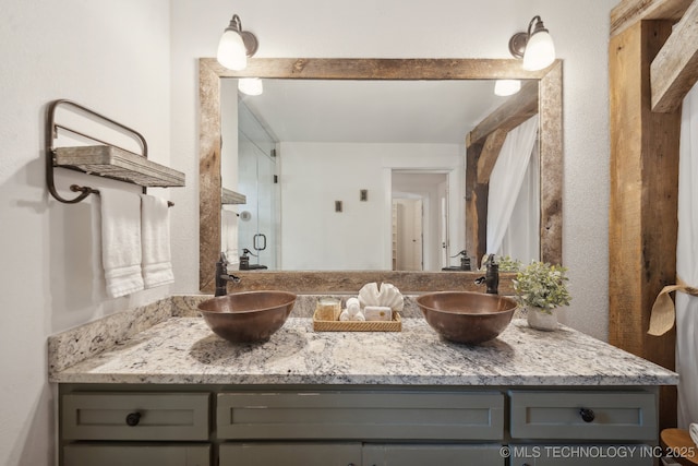 bathroom featuring a stall shower and double vanity