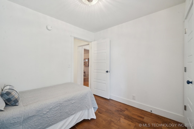 bedroom with dark wood-style floors and baseboards
