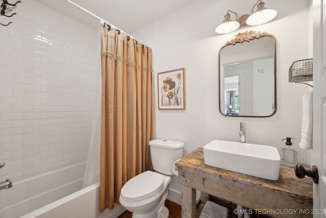 bathroom featuring toilet, a sink, and shower / bathtub combination with curtain