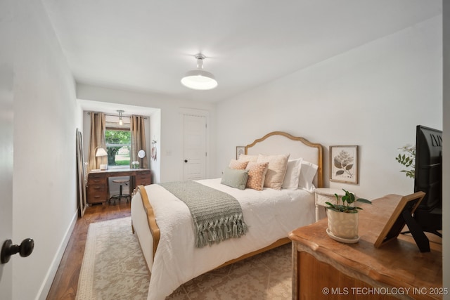 bedroom with wood finished floors and baseboards