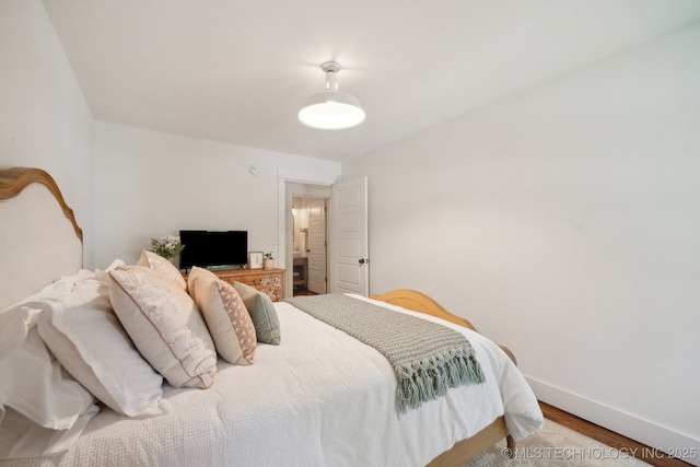 bedroom featuring baseboards and wood finished floors