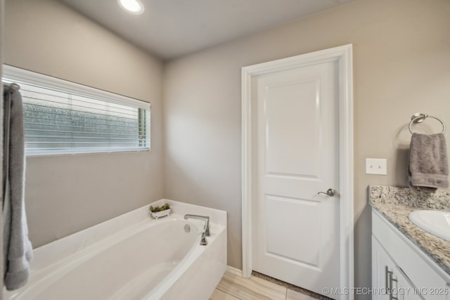 full bathroom with a garden tub and vanity
