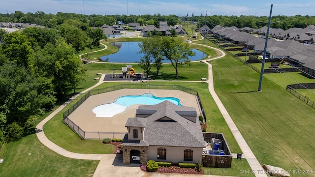 aerial view of property and surrounding area with a pool area and a large body of water