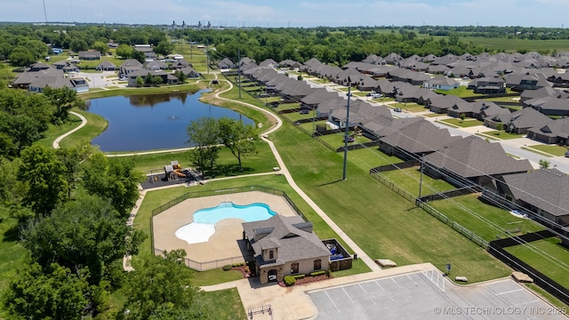 drone / aerial view of a pool and a nearby body of water