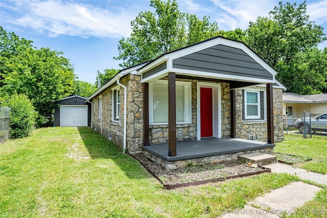 2017 N Quaker Ave, Tulsa, OK 74106 - view of front of home featuring stone siding, a garage, driveway, an outbuilding, and a porch