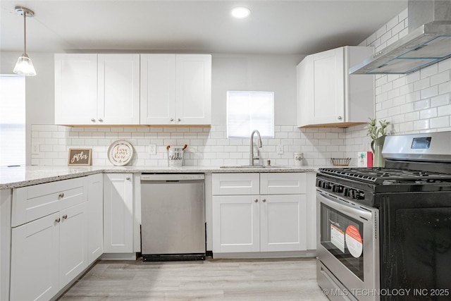 2017 N Quaker Ave, Tulsa, OK 74106 - kitchen featuring appliances with stainless steel finishes, wall chimney exhaust hood, a sink, white cabinets, and light stone countertops