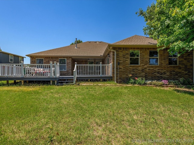 1912 Lester Ave, Bartlesville, OK 74006 - back of house featuring brick siding, a wooden deck, a lawn, and roof with shingles