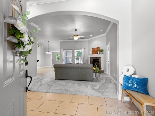 1912 Lester Ave, Bartlesville, OK 74006 - living room featuring arched walkways, light carpet, ornamental molding, a ceiling fan, and a brick fireplace