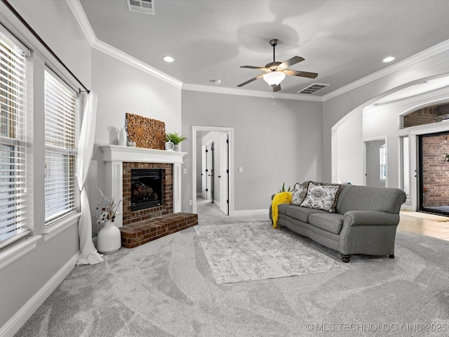 1912 Lester Ave, Bartlesville, OK 74006 - living area featuring carpet floors, arched walkways, a fireplace, ornamental molding, and baseboards