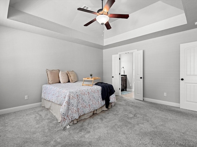 1912 Lester Ave, Bartlesville, OK 74006 - carpeted bedroom featuring a raised ceiling, baseboards, ceiling fan, and ensuite bath