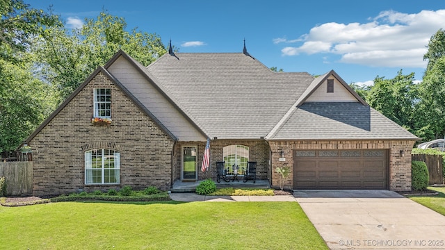 view of front of house with an attached garage, driveway, and brick siding