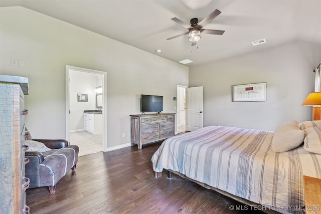 bedroom featuring wood finished floors, lofted ceiling, ensuite bath, ceiling fan, and baseboards