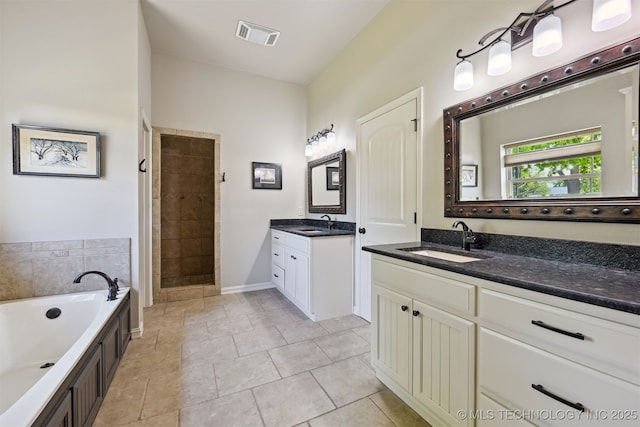 full bathroom with tile patterned floors, a garden tub, two vanities, and tiled shower