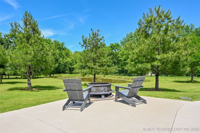 view of patio featuring a fire pit and view of scattered trees