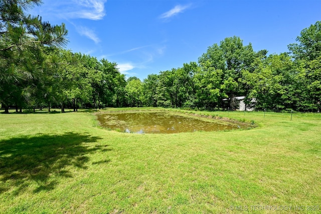 view of green lawn with a water view
