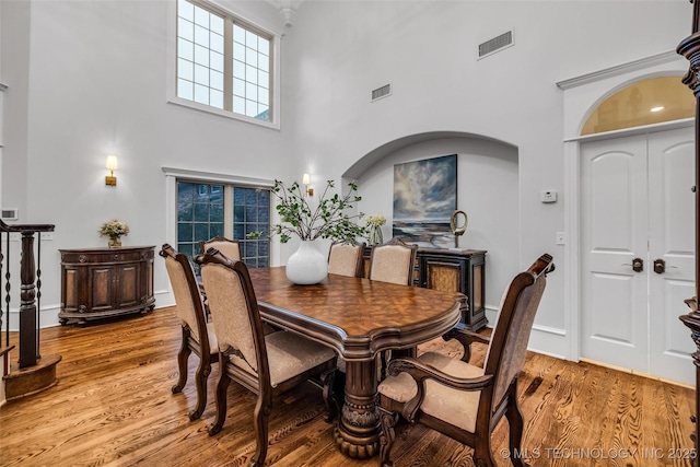 4501 E 108th Pl, Tulsa, OK 74137 - dining space featuring a high ceiling, light wood-type flooring, healthy amount of natural light, baseboards, and arched walkways