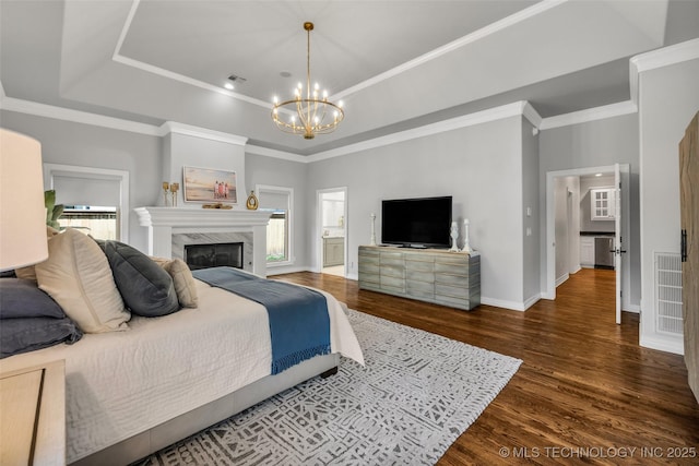 4501 E 108th Pl, Tulsa, OK 74137 - bedroom with a chandelier, a raised ceiling, dark wood-style floors, baseboards, and a premium fireplace