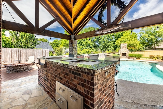 4501 E 108th Pl, Tulsa, OK 74137 - view of patio with an outdoor stone fireplace, a fenced backyard, a gazebo, and a bar