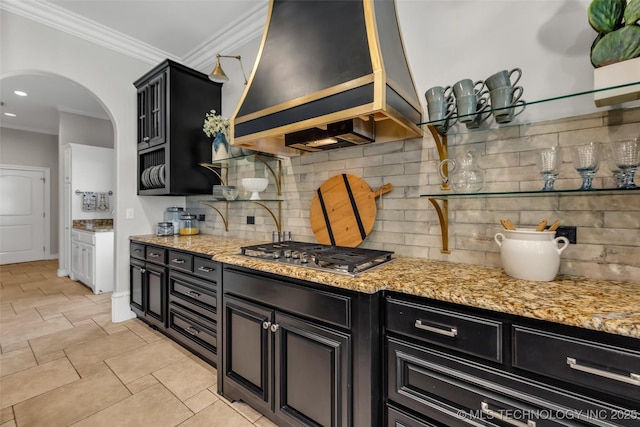 4501 E 108th Pl, Tulsa, OK 74137 - kitchen featuring stainless steel gas stovetop, dark cabinetry, ornamental molding, backsplash, and arched walkways