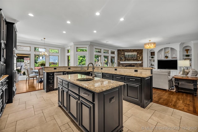 4501 E 108th Pl, Tulsa, OK 74137 - kitchen featuring an island with sink, a sink, a chandelier, open floor plan, and pendant lighting