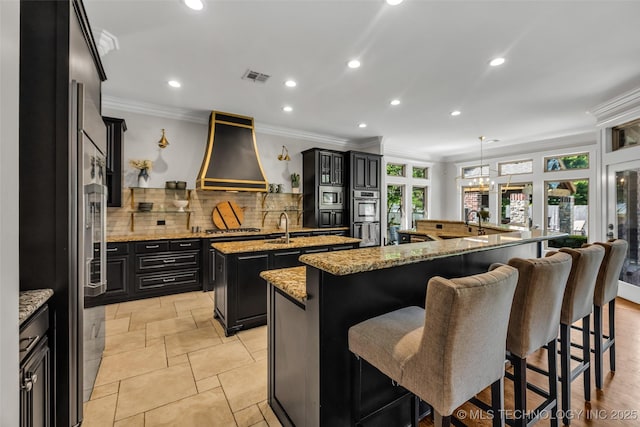 4501 E 108th Pl, Tulsa, OK 74137 - kitchen featuring a large island, premium range hood, dark cabinets, decorative backsplash, and ornamental molding