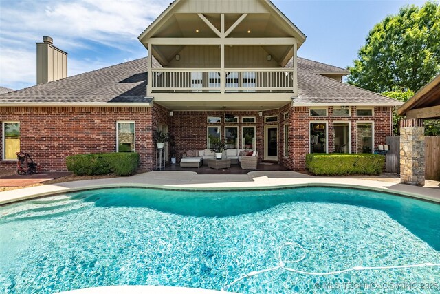 4501 E 108th Pl, Tulsa, OK 74137 - back of property with a balcony, an outdoor hangout area, roof with shingles, and brick siding