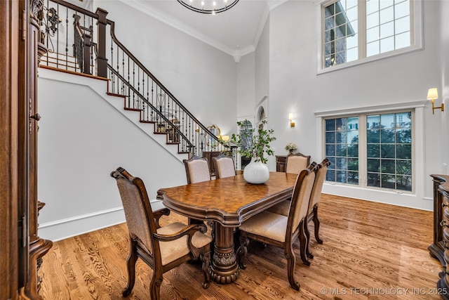 4501 E 108th Pl, Tulsa, OK 74137 - dining space featuring crown molding, a high ceiling, stairs, wood finished floors, and plenty of natural light