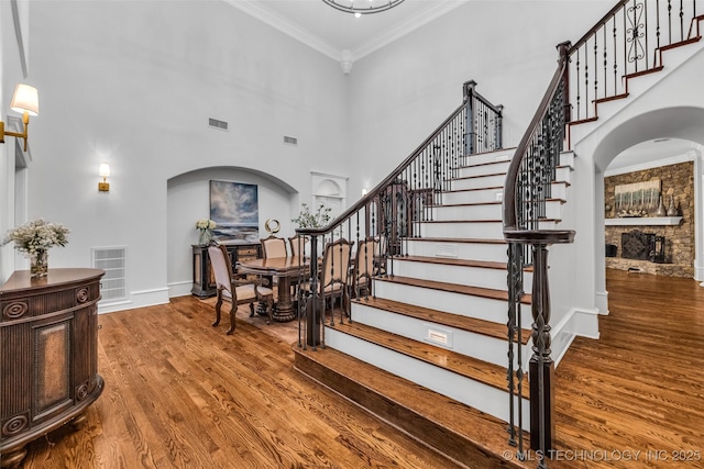 4501 E 108th Pl, Tulsa, OK 74137 - stairs featuring arched walkways, wood finished floors, crown molding, a high ceiling, and baseboards