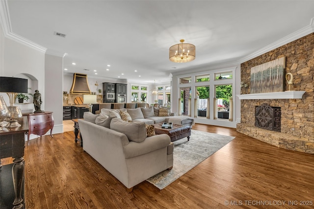 4501 E 108th Pl, Tulsa, OK 74137 - living room featuring ornamental molding, a chandelier, a fireplace, wood finished floors, and recessed lighting