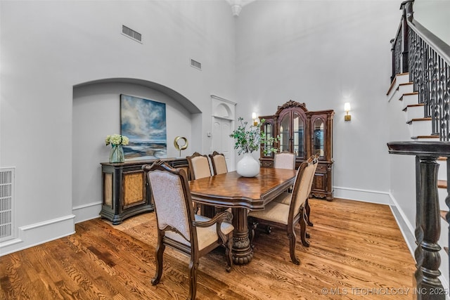 4501 E 108th Pl, Tulsa, OK 74137 - dining room with a high ceiling, wood finished floors, stairway, baseboards, and arched walkways
